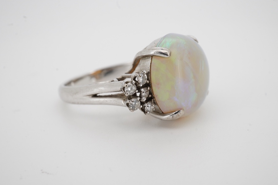 A 9k white metal and single stone cabochon white opal set dress ring, with ten stone diamond set shoulders, size P, gross weight 6.5 grams. Condition - poor